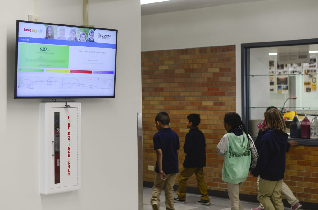 Children walk past a screen displaying air quality information at Swansea Elementary School on Oct. 17, 2019. (Lindsay Fendt