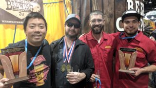 From left: owner David Lin, head brewer Marks Lanham, Jake Lancaster and Rio Urioste of Comrade Breweing Co. team pose with their awards at Great American Beer Festival. Oct. 5, 2019. (Eric Gorski for Denverite)