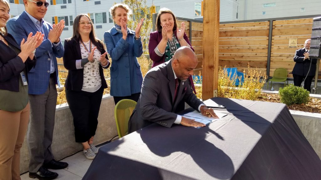Mayor Michael Hancock signs an executive order establishing Denver's new housing department on Oct. 23, 2019. (Donna Bryson/Denverite)