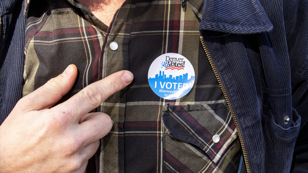 Ryan Garrett points to his pin after voting on Election Day, Nov. 5, 2019.