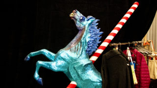 This scary blue horse appears to have been impaled by a peppermint spear. Lonnie Hanzon's "Camp Christmas" under construction at Stanley Marketplace. Nov. 15, 2019. (Kevin J. Beaty/Denverite)