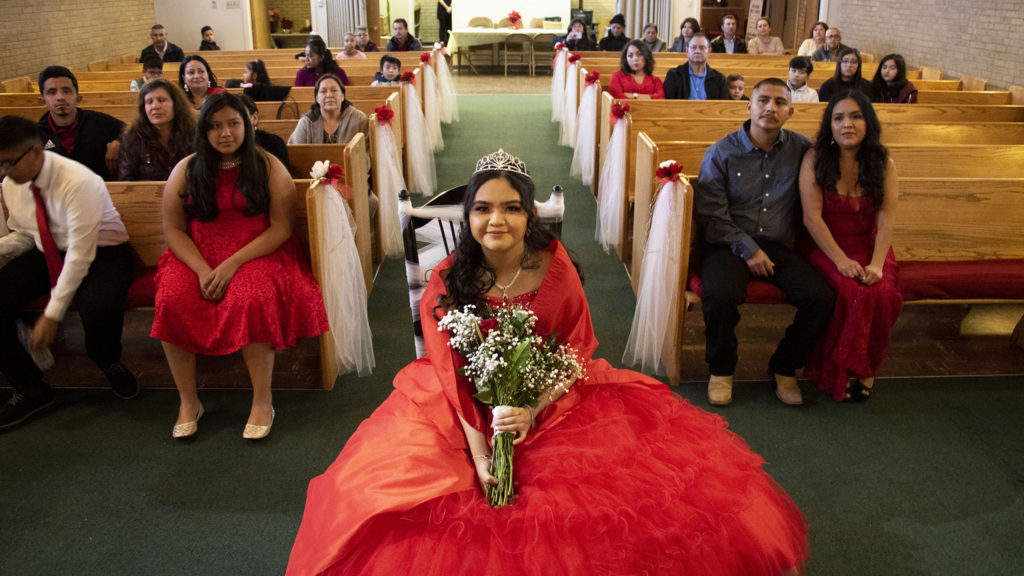 Kim Ramos sits in a chair adorned with lace before her quinceañera ceremony began. Ministerio Hispano Presbyterian Church, Dec 14, 2019. (Kevin J. Beaty/Denverite)