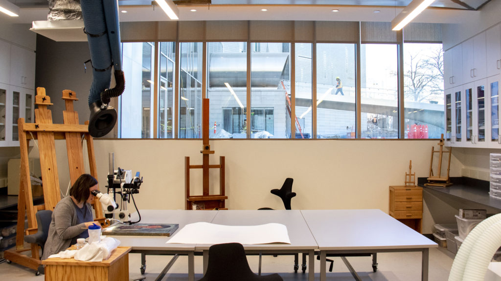 Conservator Pam Skiles works on a 1918 painting by Amedeo Modigliani beneath big new windows in the Denver Art Museum's new restoration lab. Dec. 17, 2019. (Kevin J. Beaty/Denverite)