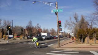 A cyclist rides at the intersection of Quebec Street and 17th Avenue on Monday, Dec. 16, in Denver. (Esteban L. Hernandez/Denverite)