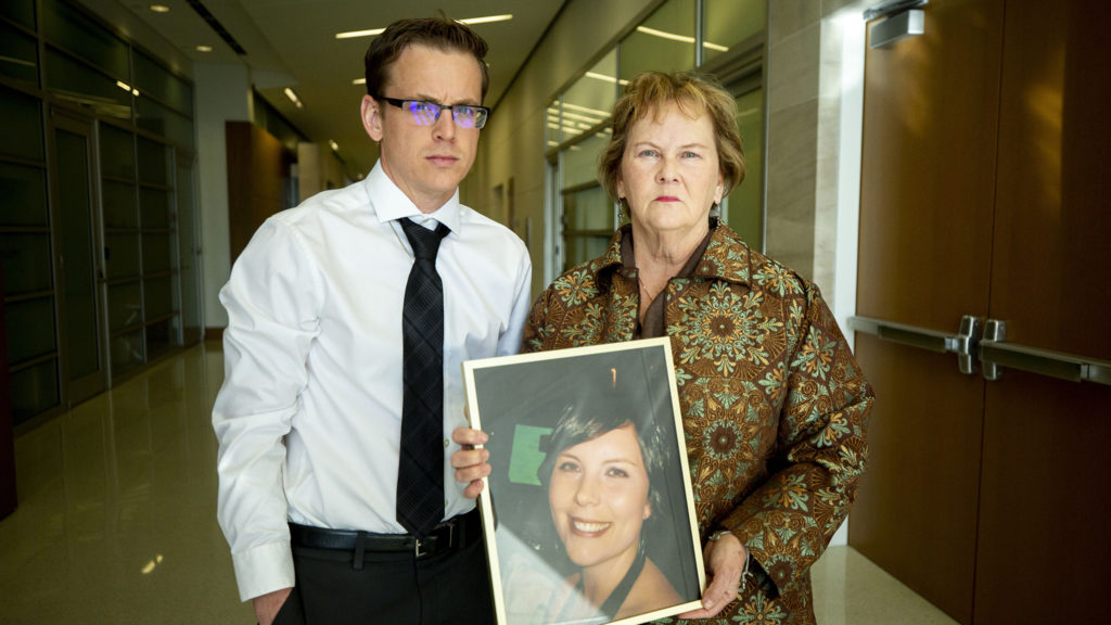 Teddy Bounds and Peggy Boardman hold pose for a portrait with a photo of Alexis Bounds, who was killed in an accident while on her bike. Jan. 24, 2020. (Kevin J. Beaty/Denverite)