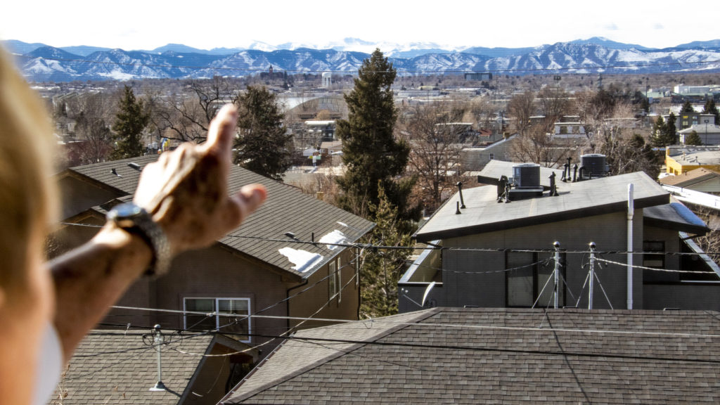 Sandy Pierce looks out onto the view from her home in Denver's Rosedale neighborhood. Feb. 27. 2020. (Kevin J. Beaty/Denverite)