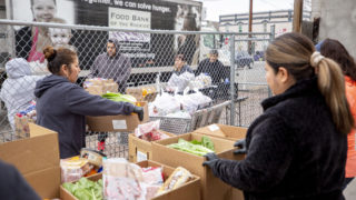Volunteers pack groceries at the Twin Parishes food pantry in Cole. It's the first time in 40 years they've had to do this outside. March 17, 2020. (Kevin J. Beaty/Denverite)