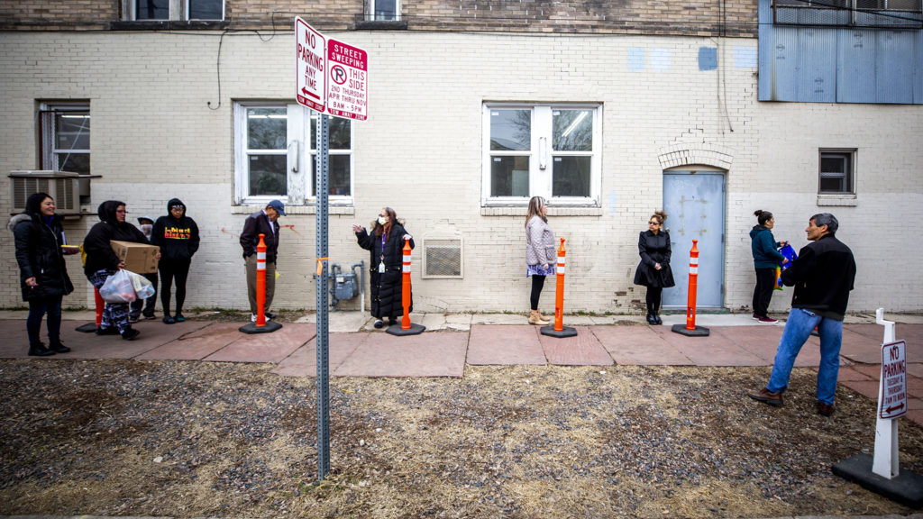 People line up for their monthly allotment of groceries from the Twin Parishes food pantry in Cole. It's the first time in 40 years they've had to do this outside. March 17, 2020. (Kevin J. Beaty/Denverite)