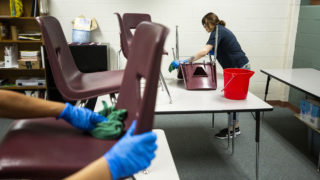 A facilities crew wipes down surfaces at Bruce Randolph School during an extended COVID-19 spring break. March 19, 2020. (Kevin J. Beaty/Denverite)