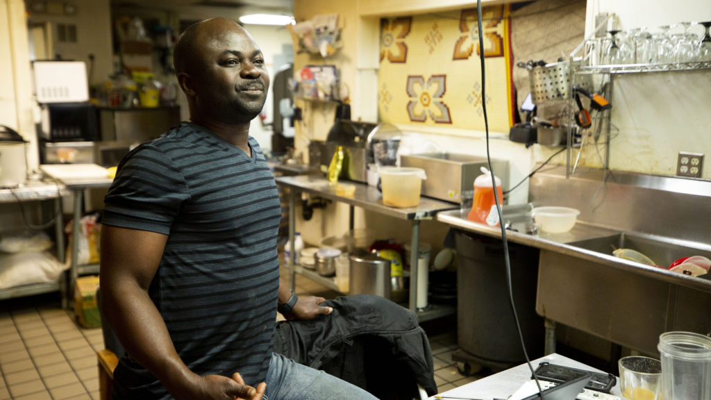 Sylvester Osei-Fordwuo, co-owner of African Grill and Bar, waits for his next order. Green Valley Ranch, March 20, 2020. (Kevin J. Beaty/Denverite)
