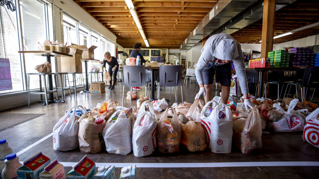 Alex Chavarria organizes groceries inside the Sun Valley Kitchen, March 25, 2020. (Kevin J. Beaty/Denverite)