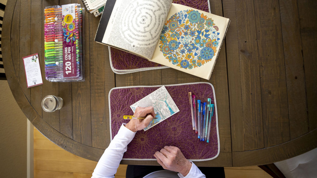Debbie Fox fills in blocks of a coloring page inside her Arvada home. March 26, 2020. (Kevin J. Beaty/Denverite)