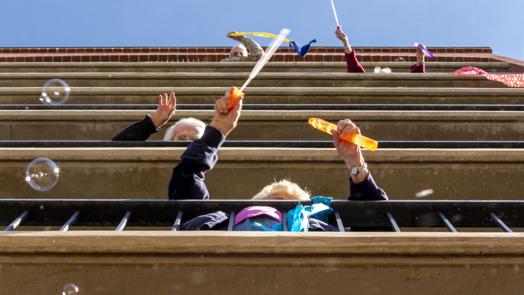 Residents of the Springbrooke Senior Living center sing and dance above their courtyard. Washington Virginia Vale, March 27, 2020. (Kevin J. Beaty/Denverite)