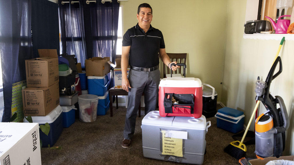 Jesus Velazquez poses for a portrait in his home with his burrito coolers, March 31, 2020. (Kevin J. Beaty/Denverite)
