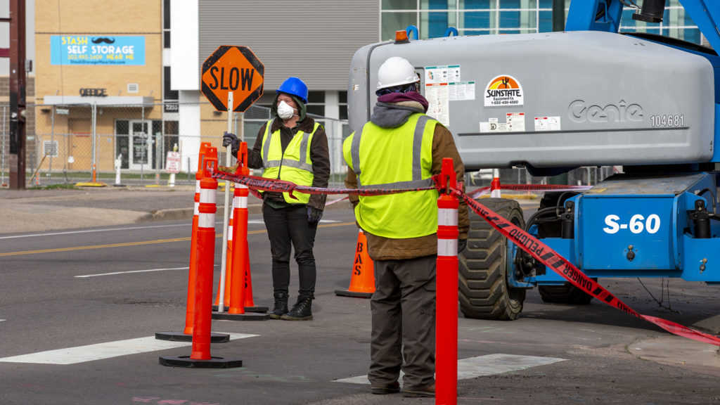 A construction flagger wears a mask at Park Avenue and Champa Street in Five Points, April 1, 2020. (Kevin J. Beaty/Denverite)