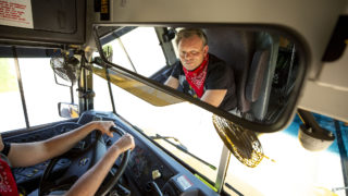 DPS bus driver Jack Rutten helms a mobile food pantry parked outside of Schmitt Elementary School in Ruby Hill. May 6, 2020. (Kevin J. Beaty/Denverite)