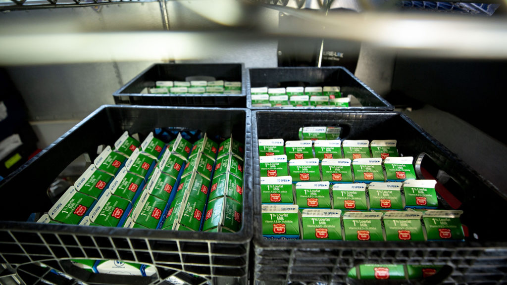 Cartons of milk inside a DPS bus full of food and parked outside of Schmitt Elementary School in Ruby Hill. May 6, 2020. (Kevin J. Beaty/Denverite)