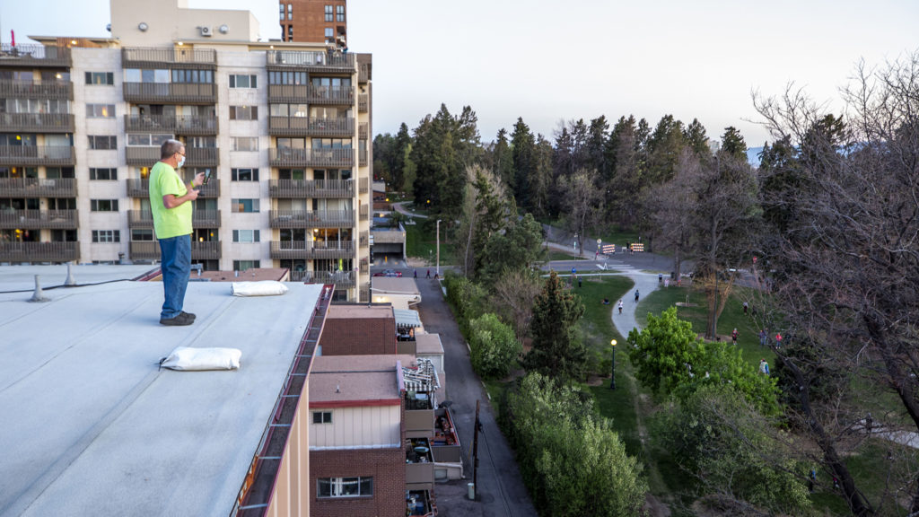 Jim Scharper streams his one-song roof concert as his friends wach from below. May 7, 2020. (Kevin J. Beaty/Denverite)