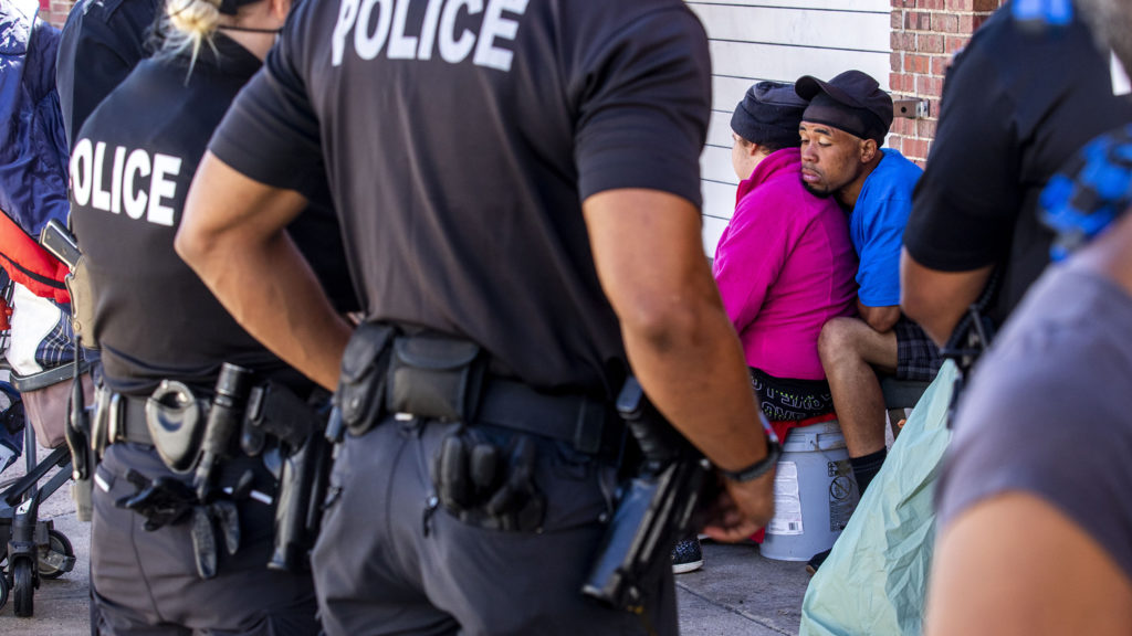 Christopher Johnson leans on his wife, Christina, after authorities instructed the couple to move their camp from the corner of California and 21st Streets. May 27, 2020. (Kevin J. Beaty/Denverite)
