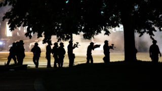 Denver Police officers in riot gear aim guns loaded with pepper balls toward protesters. May 29, 2020. (Kevin J. Beaty/Denverite)