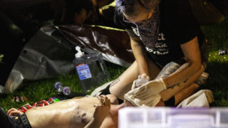 A medic treats a man still crying from tear gas. May 30, 2020. (Kevin J. Beaty/Denverite)