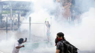 Officers covered a crowd surrounding Denver Police District Six's headquarters with tear gas on the third day of protests in reaction to the killing of George Floyd. May 30, 2020. (Kevin J. Beaty/Denverite)