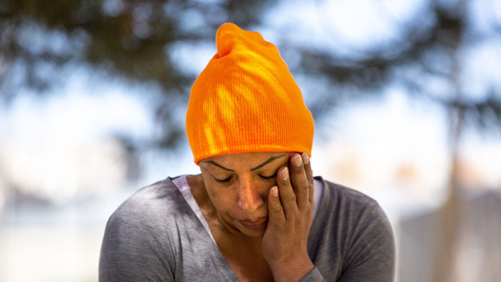 Mireya Marquez sits in the shade at the Highland motel where she was living. April 28, 2020. (Kevin J. Beaty/Denverite)
