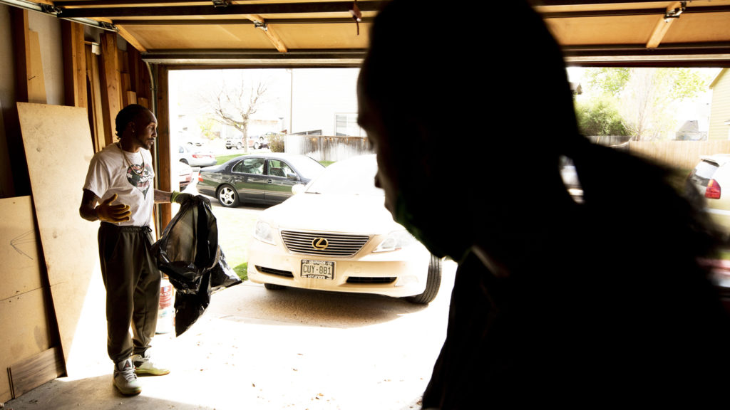 Joel Hodge and his "little" brother-in-law, Eris Griffin, in Hodge's Montbello garage on a Saturday when he's waiting for a call from Denver Police to direct him to the family of a shooting victim who he plans to visit. May 17, 2020. (Kevin J. Beaty/Denverite)