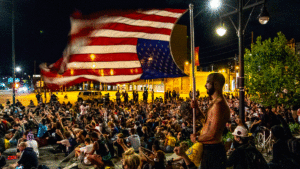 Devin S. waves a large, upside down American flag, during nine minutes of silence on the sixth day of protests in reaction to the killing of George Floyd by Minneapolis police. June 2, 2020. (Kevin J. Beaty/Denverite)