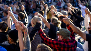 The crowd holds hands during a vigil for George Floyd at Civic Center Park. June 9, 2020. (Kevin J. Beaty/Denverite)