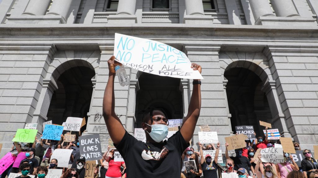 Elliot Sam, originally from Ghana and visiting Denver, helps lead a chant for educators opposing racism and police brutality and supporting Black Lives Matter at the state Capitol Thursday, June 11, 2020. (Hart Van Denburg/CPR)