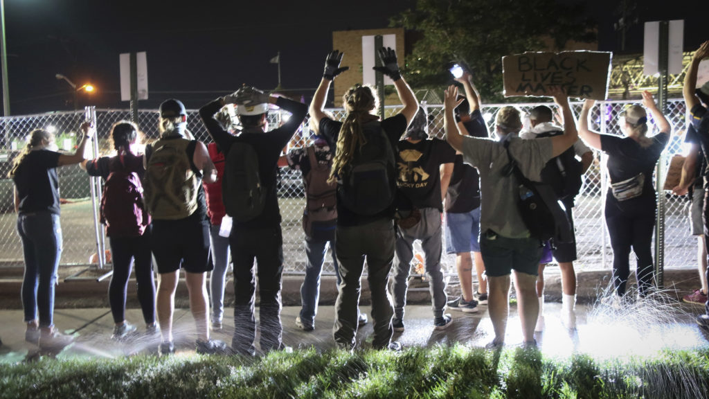 Protesters hold up their hands and chant "I can't breathe" at the Denver Police Department's District Six building off Colfax Avenue on Friday, June 5, 2020.
