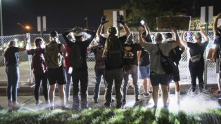 Protesters hold up their hands and chant "I can't breathe" at the Denver Police Department's District Six building off Colfax Avenue on Friday, June 5, 2020.