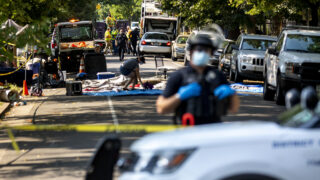 Denver Police officers enforce a cleanup of an encampment in front of Morey Middle School. Capitol Hill, Aug. 6, 2020.