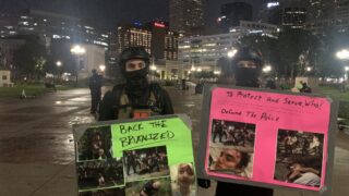 Self-styled "defenders" hold up illustrated shields before a late night protest in Denver, August 28, 2020.