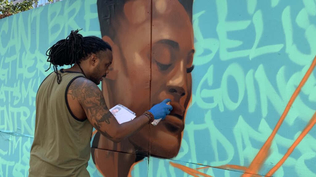 Vince Ballentine painting a mural of Elijah McClain in New York City. Photo by Carmelo Nieves.