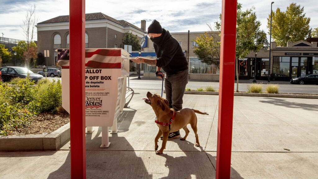 Hank Murphy and Deedee cast a ballot for the November 2020 election outside of the Carla Madison Rec Center on Colfax Avenue. Oct. 16, 2020.