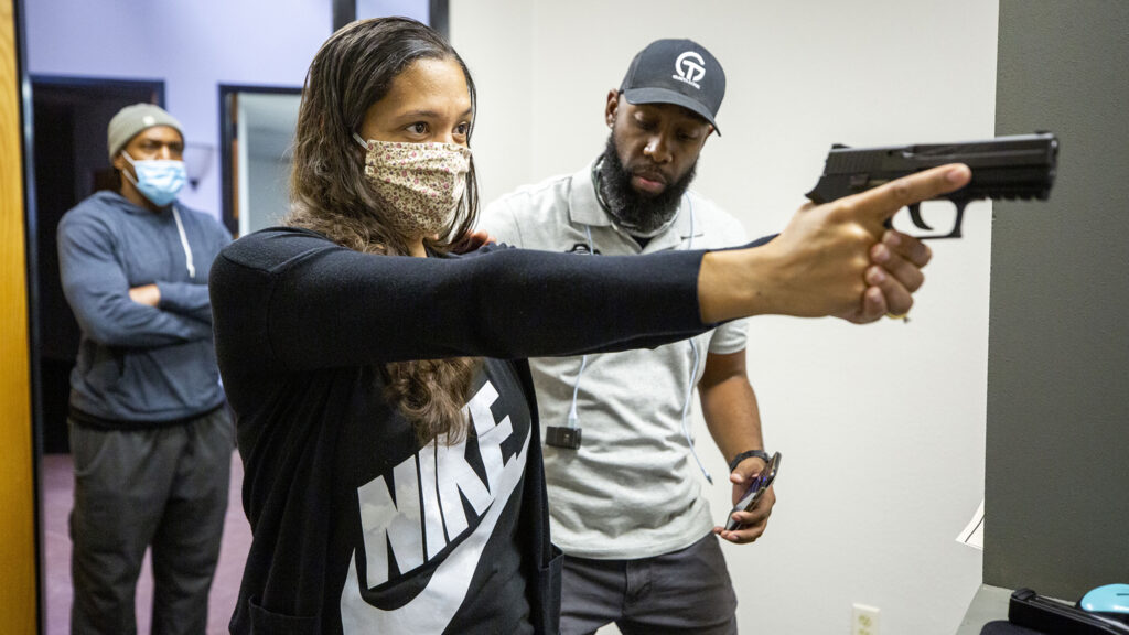 Instructor Anubis Heru works with Ikaika Hill inside 17 Seventy Armory and Gun Club's new "virtual" range in Five Points. Oct. 17, 2020.