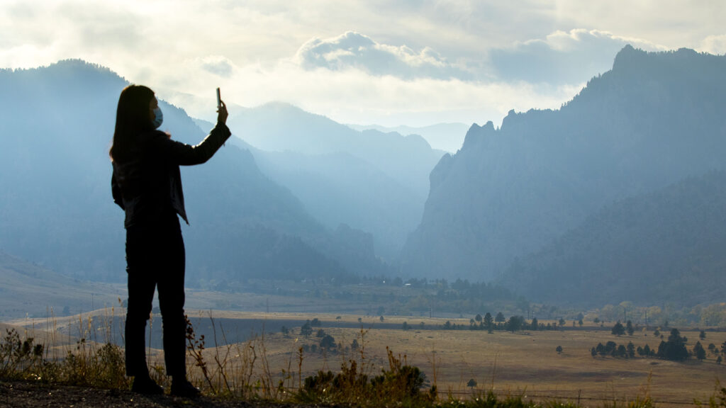 Lucy Wang snaps a photo as clouds and haze from two nearby fires hang over the hills near State Highway 93 in Boulder County. Oct. 18, 2020.