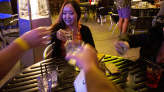 May Gantugs clinks glasses with an old friends and two new ones as the Denver Pub Crawl group prepares to leave its first stop at Brother's Bar and Grill in LoDo. Oct. 23, 2020.