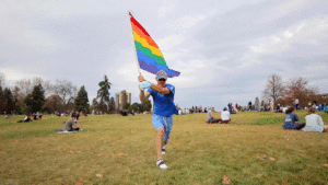 Ty Bradford waves his pride flag as Denverites gathered at Cheesman Park celebrate Joe Biden's victory in the U.S. presidential election. Nov. 7, 2020.