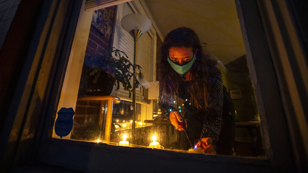 Denver Streets Partnership Executive Director Jill Locantore lights candles in the window of her City Park West home for a World Day of Remembrance for people killed in traffic crashes. Nov. 18, 2020.