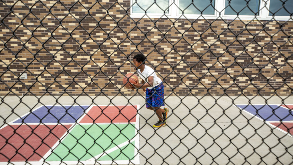 A kid plays basketball at the Dahlia Campus for Health and Well Being at the eastern end of Bruce Randolph Avenue. Sept. 11, 2020.