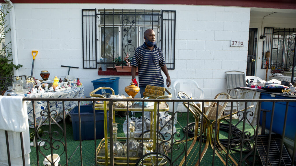 Daniel Bodison sets some old family possessions out for sale in front of his home along Bruce Randolph Avenue. Sept. 11, 2020.