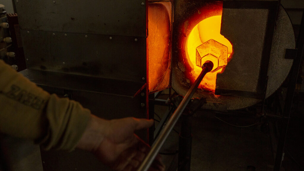 Nate Steinbrink pulls an in-progress light fixture out of a glowing kiln inside his Flux Studio workshop at Bruce Randolph Avenue and Elizbeth Street. Dec. 14, 2020.