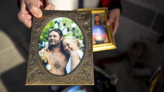 Stacy Neill holds a photo of her and her late partner, Todd Ham, in front of The Fourth Quarter apartments in Whittier. Dec. 17, 2020.