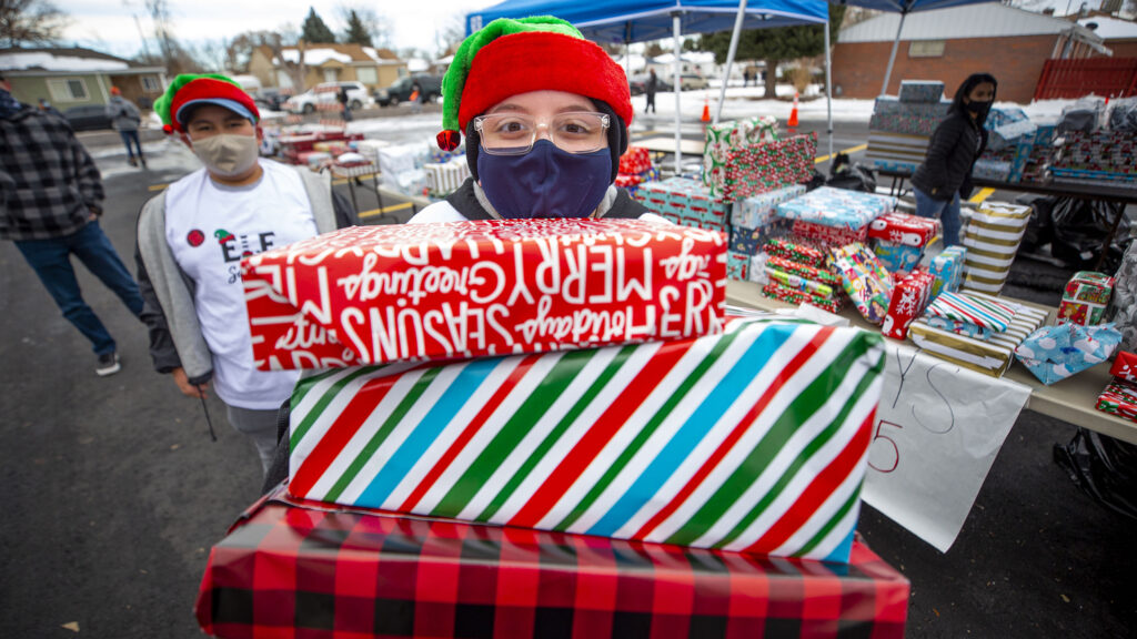 Andrew, 12, hands out free wrapped gifts during Victory Outreach Church's annual toy giveaway in Athmar Park. Dec. 19, 2020.