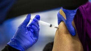 Yvonne Gutierrez gets the first round of a Moderna COVID-19 vaccine at the Denver Indian Center, part of the second wave of prioritized shots in the city. Jan. 8, 2020.