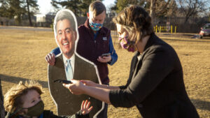 Katie Farnan meets Sentator John Hickenlooper in City Park to hand off one of the "Cardboard Cory" Gardners that she used for four years to protest Gardner's policies and dearth of public town halls, Jan. 14, 2021.
