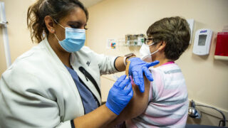 Medical assistant Yasmin Tellez gives Maria Chacon the first of two Moderna COVID-19 vaccinations at Globeville's Clinica Tepeyac. Jan. 26, 2021.